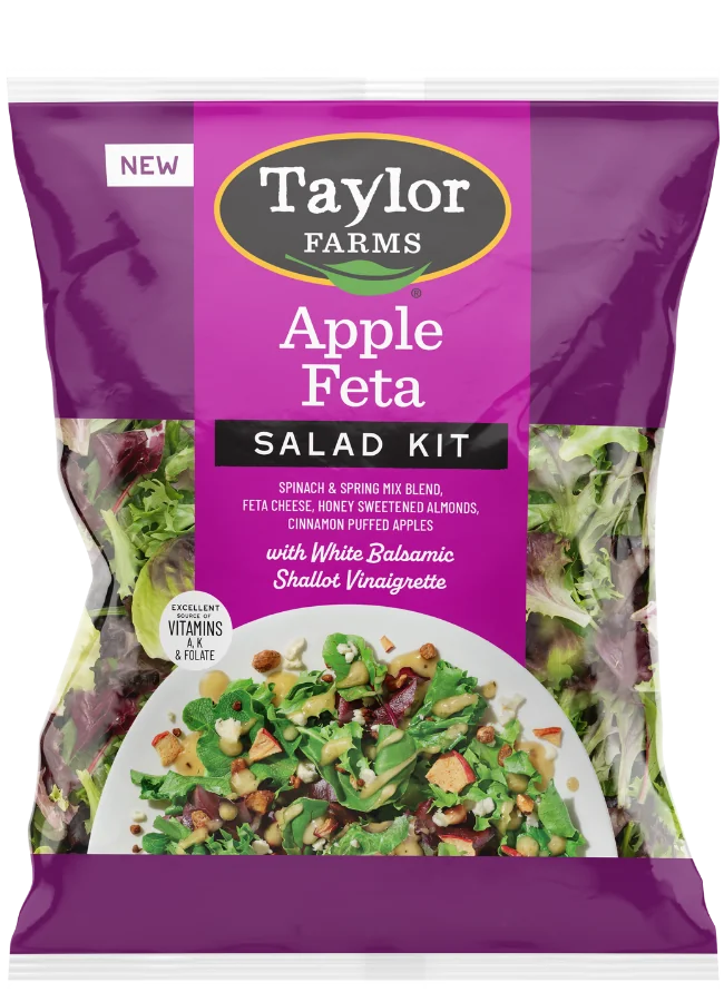 The Taylor Farms Apple Feta Salad Kit package, showing spinach, spring mix, feta cheese bits, almonds, pieces of puffed apple, and white balsamic shallot vinaigrette.