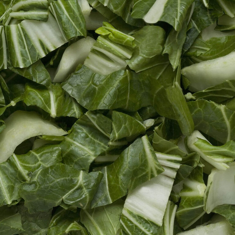Fresh bok choy on a wooden surface, showcasing its vibrant green leaves and crisp texture, perfect for healthy meals.