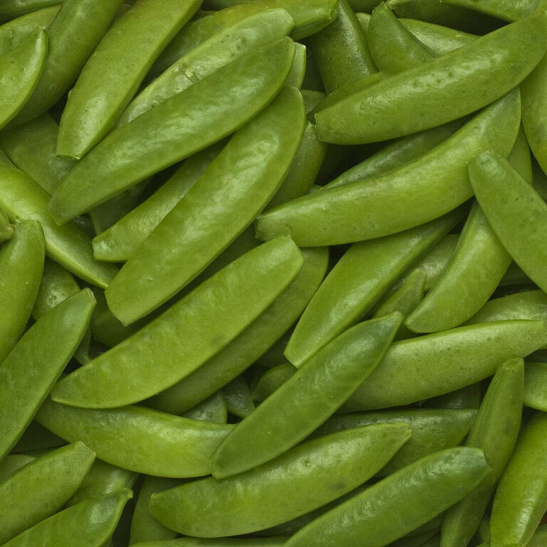 Fresh snap peas piled in a bowl, showcasing their vibrant green color and crisp texture, perfect for healthy recipes.