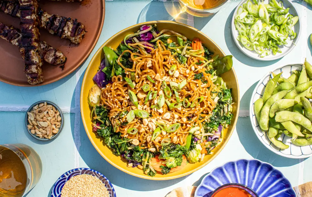 Teriyaki noodles served with grilled chicken skewers, a delicious recipe from Taylor Farms.