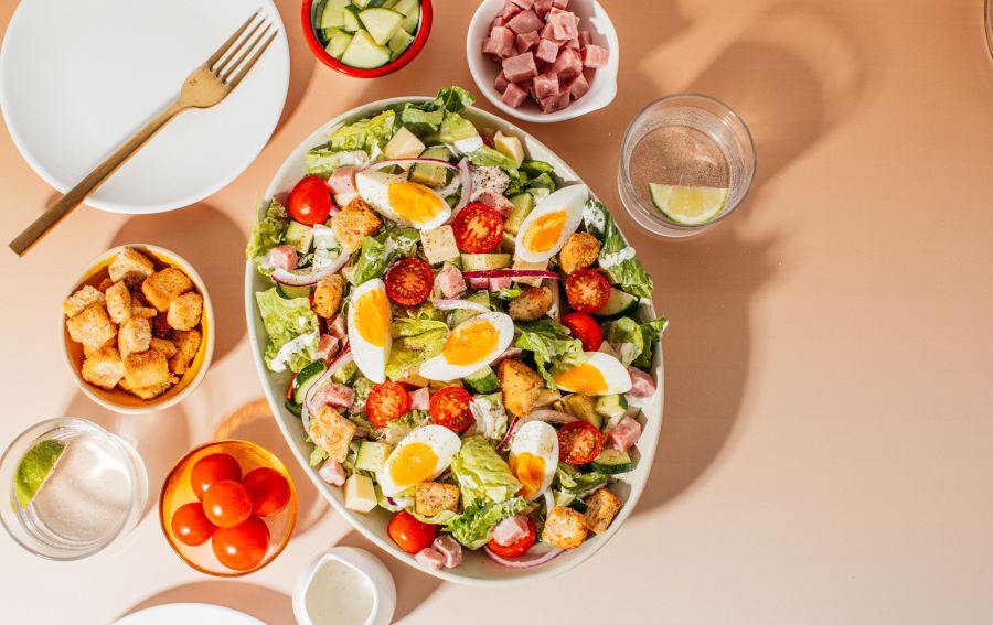 Freshly prepared salad featuring vibrant greens, cherry tomatoes, and colorful vegetables from Taylor Farms.