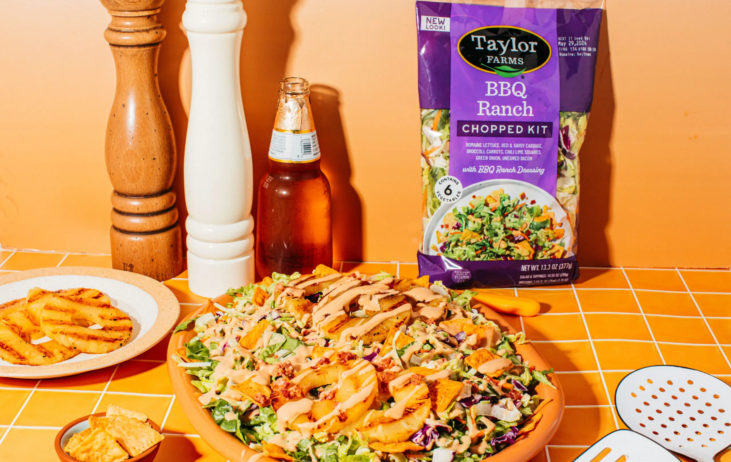 Freshly harvested greens and colorful vegetables in a sunny outdoor farm setting by Taylor Farms.