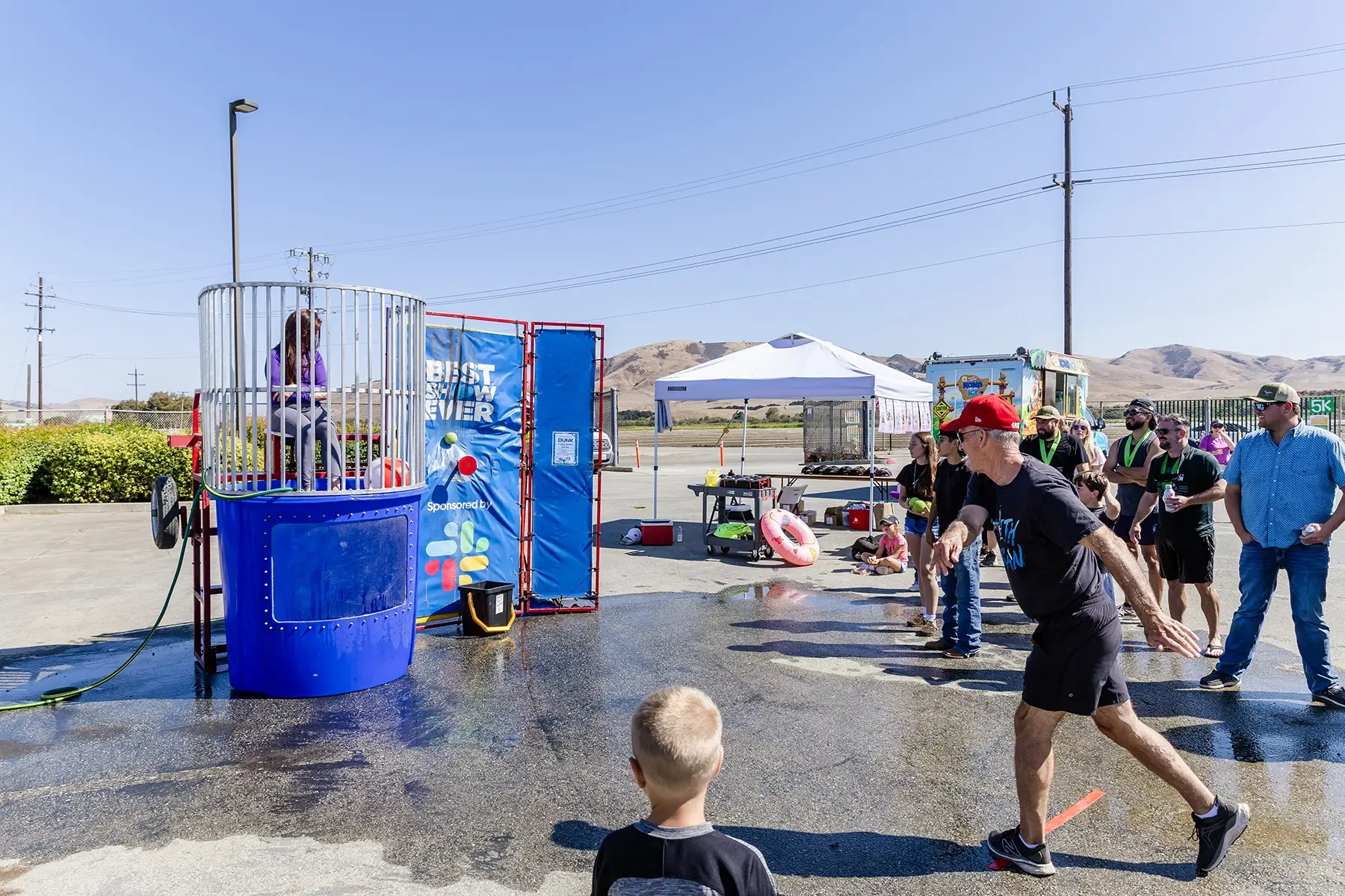 Participants running in the 2024 Taylor Farms Ranch Run amidst greenery and festive banners.