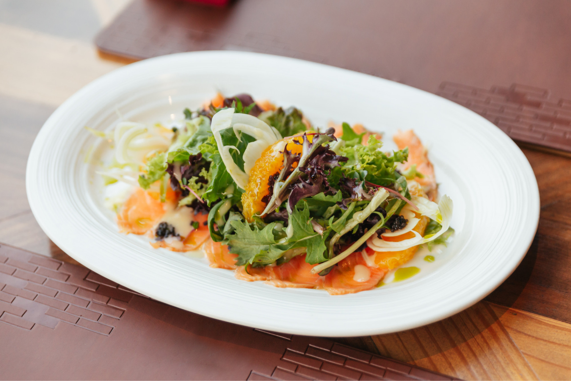 Fresh red leaf lettuce on a white plate, showcasing vibrant color and crisp texture, perfect for salads and garnishes.